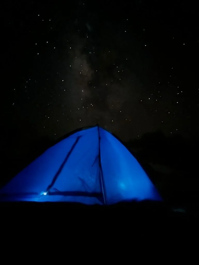 Tienda de campaña iluminada bajo un cielo estrellado en Ría Lagartos, Yucatán.