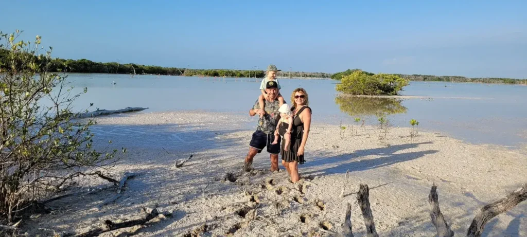 Familia caminando sobre bancos blancos del humedal de Ría Lagartos